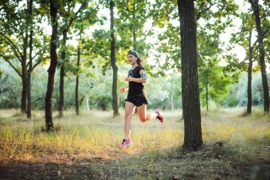 parkta çalışan genç beyaz kadın. Kadın parkta koşu