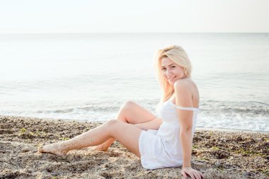 genç güzel beyaz kadın gündoğumu veya günbatımı sırasında plajda güneşin tadını