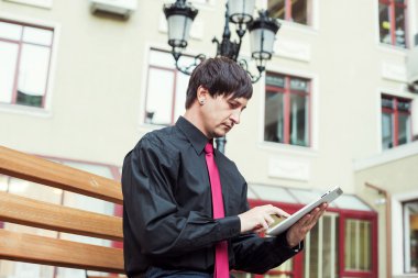 Açık havada tablet kullanan bir iş adamı.