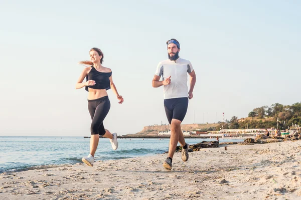 运行人-女人和男人在海滩上慢跑运动员赛跑者。适合年轻健身夫妇在日出或日落户外锻炼健康的生活方式 — 图库照片