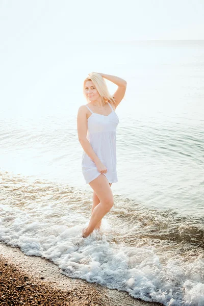 Giovane bella femmina caucasica godersi il sole sulla spiaggia durante l'alba o il tramonto — Foto Stock