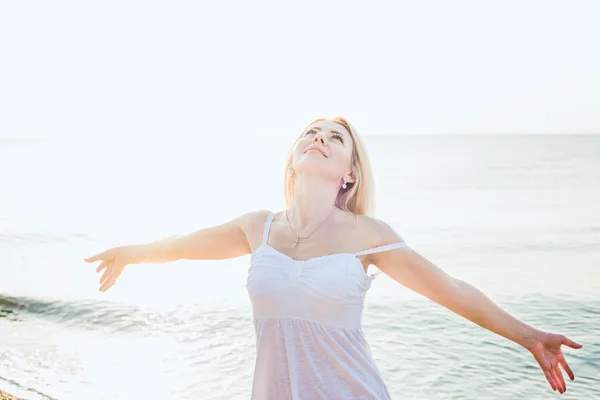 Jeune belle femme caucasienne profiter du soleil sur la plage pendant le lever ou le coucher du soleil — Photo