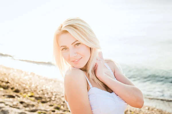 Jeune belle femme caucasienne profiter du soleil sur la plage pendant le lever ou le coucher du soleil — Photo