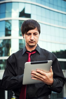 Açık havada tablet kullanan bir iş adamı.