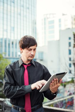 Açık havada tablet kullanan bir iş adamı.