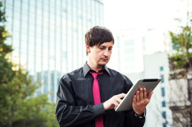 Açık havada tablet kullanan bir iş adamı.