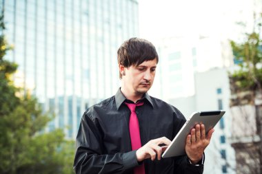 Açık havada tablet kullanan bir iş adamı.