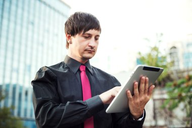 Açık havada tablet kullanan bir iş adamı.