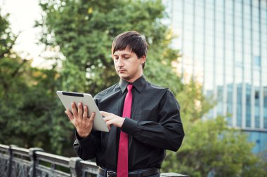 Açık havada tablet kullanan bir iş adamı.