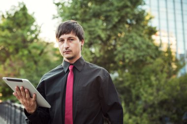 Açık havada tablet kullanan bir iş adamı.