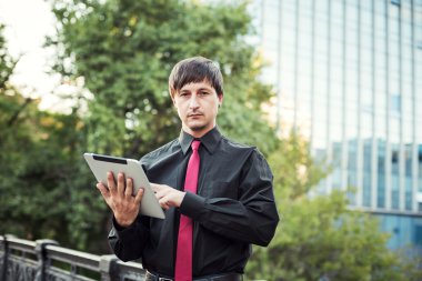 Açık havada tablet kullanan bir iş adamı.