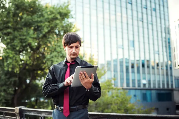 Açık havada tablet kullanan bir iş adamı.