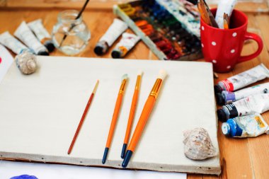 suluboya boya, yağlı boya, cep telefonu, gözlük ve fırçalar sanatçının studio tablo.