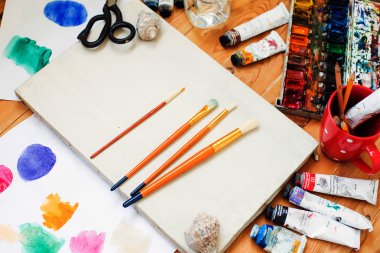 suluboya boya, yağlı boya, cep telefonu, gözlük ve fırçalar sanatçının studio tablo.