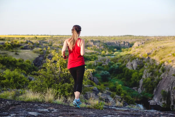 Stien går i slukta. Ung kaukasisk modell som løper i vakkert steinlandskap / kvinnelig løper i canyon . – stockfoto