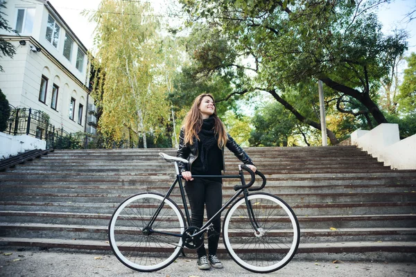 Jovem fêmea montando uma bicicleta, menina com bicicleta de engrenagem fixa — Fotografia de Stock