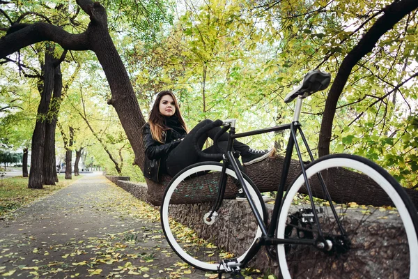 Jovem fêmea montando uma bicicleta, menina com bicicleta de engrenagem fixa — Fotografia de Stock