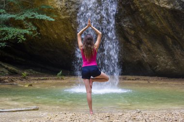 pratik Yoga şelalenin yakınındaki genç beyaz kadın