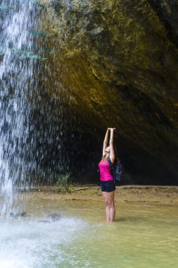 Şelalenin yakınındaki genç beyaz kadın fiyatı