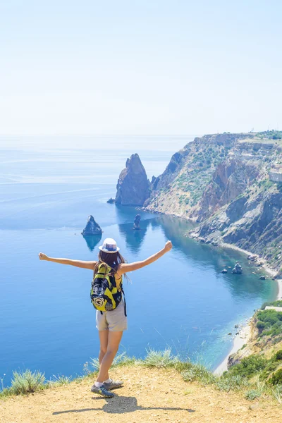 Joven caucásico hembra senderismo en un acantilado sobre el mar —  Fotos de Stock