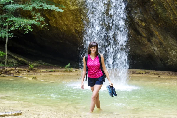 Young caucasian female hiker near the waterfall — Stock Photo, Image
