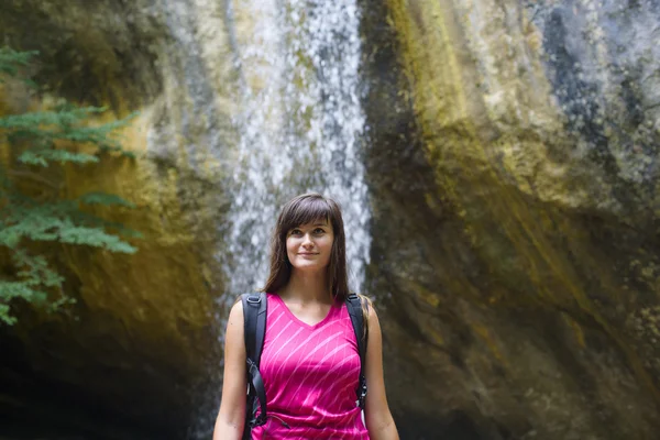 Young caucasian female hiker near the waterfall — Stock Photo, Image