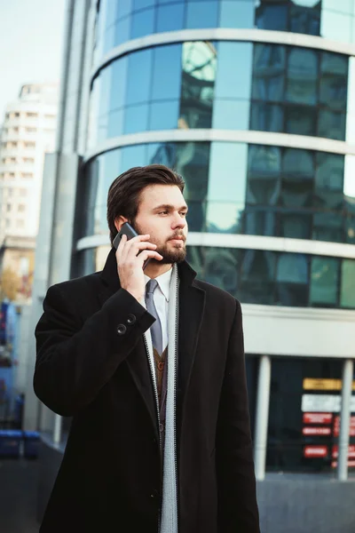 Młody biznesmen kaukaski rozmawia w pobliżu centrum biznesowego telefonu — Zdjęcie stockowe