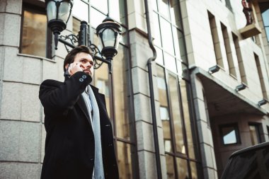 İş Merkezi yakınlarındaki telefonda konuşan işadamı