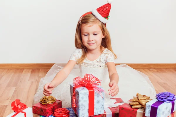 Liten flicka med jul eller födelsedag presenterar sitter på golvet — Stockfoto