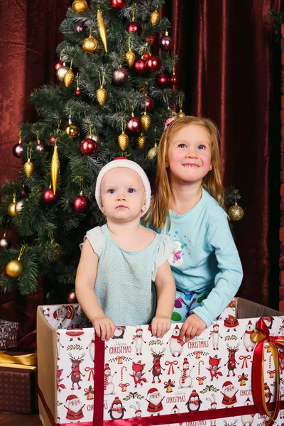 Due bambine che giocano con i regali nelle decorazioni natalizie — Foto Stock