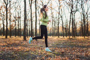 parkta çalışan erkek. Genç kadın sonbahar ormanda koşu