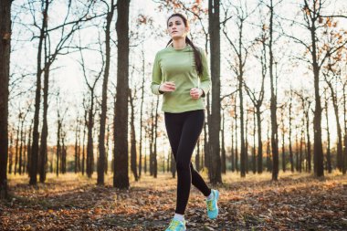 parkta çalışan erkek. Genç kadın sonbahar ormanda koşu