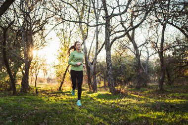 parkta çalışan erkek. Genç kadın sonbahar ormanda koşu
