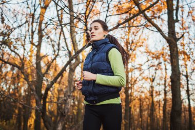 parkta çalışan erkek. Genç kadın sonbahar ormanda koşu