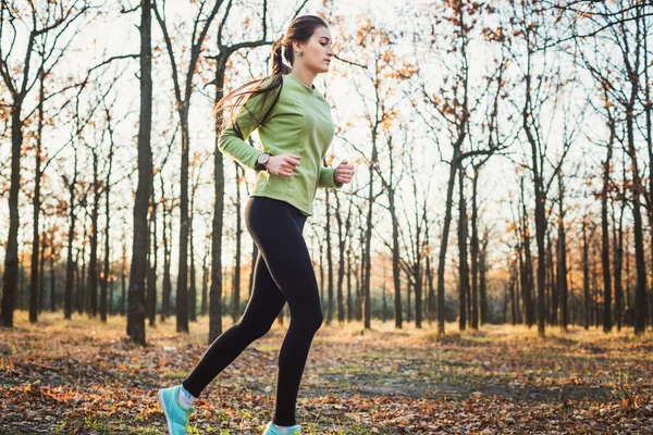 Mulher a correr no parque. Jovem jogging mulher na floresta de outono — Fotografia de Stock