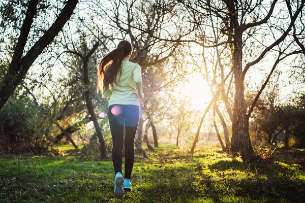 Mujer corriendo en el parque. Mujer joven corriendo en el bosque de otoño — Foto de Stock