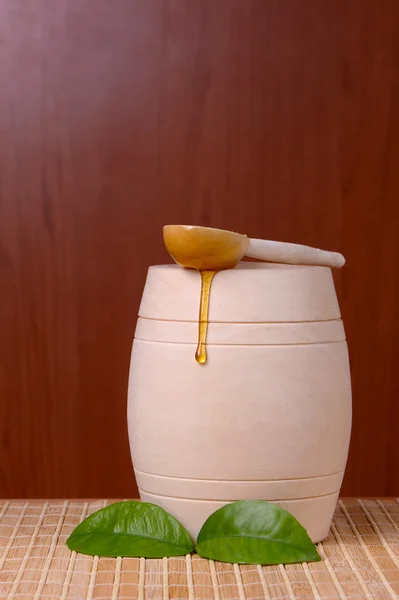 Barrel of honey with a spoon lying on it — Stock Photo, Image