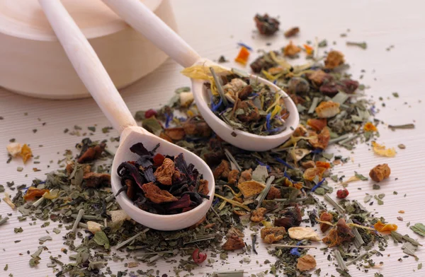 Assortment of dry tea in spoons, on wooden background — Stock Photo, Image