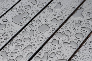 Raindrops on the surface. Water on the surface. After the rain. Water drops. Wooden boards.