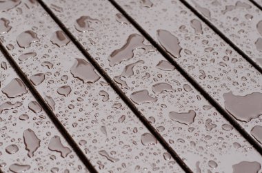 Tahta tahtalar. Yüzeyde yağmur damlaları. Islak yüzey.