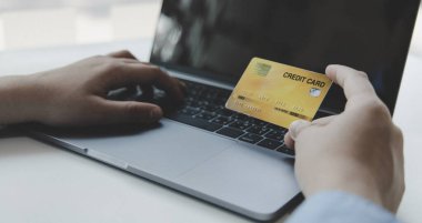 Çevrimiçi ürün alımı, İşadamı çevrimiçi alışveriş, alışveriş ve posta, kredi kartı çevrimiçi güvenlik, çevrimiçi alışveriş konsepti yapmak için kredi kartları yoluyla dizüstü bilgisayarı kullanır