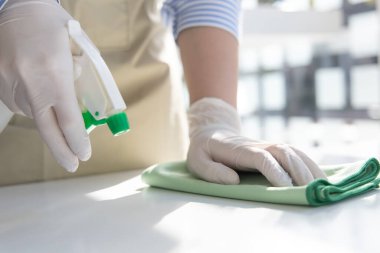 Personel el elini kapatın. Restoran çalışanları virüs salgını sırasında masaları temizliyor ve dezenfektanları püskürtüyor, temizlik çözümleri kullanıyor ya da restorandaki mikropları öldürmek için alkol kullanıyor..