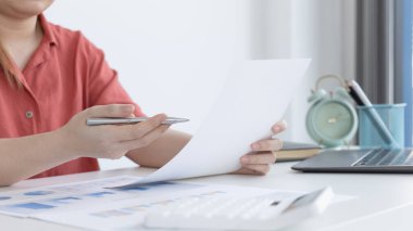 Asyalı kadınlar grafikleri, pazar verilerini ve yatırım risklerini analiz ediyor, virüs salgını veya sosyal alanlarda evde çalışıyor, mikropları yaymaktan kaçınıyor.