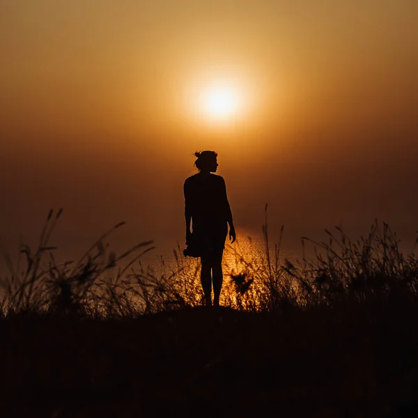 Silueta de chica al atardecer en el océano — Foto de Stock