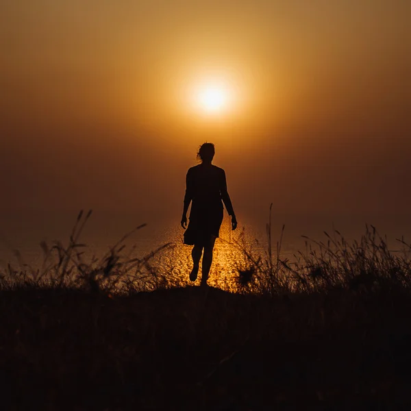 Silueta de chica al atardecer en el océano —  Fotos de Stock