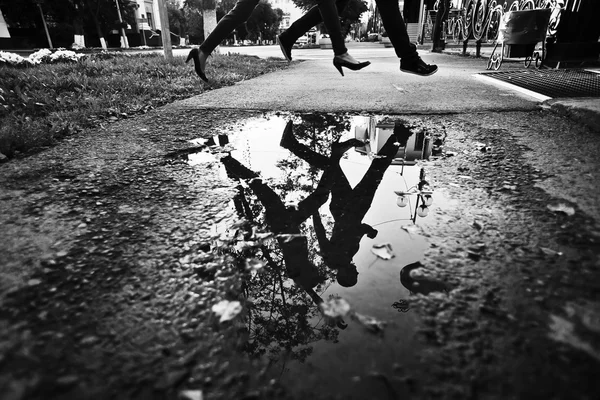 pedestrians reflected in puddle black and white photo