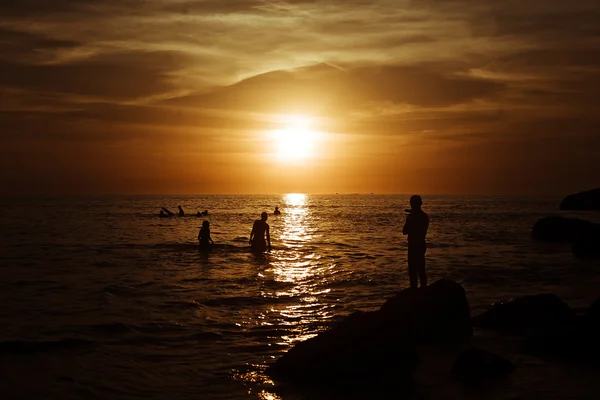 Surfeando en Sunset. Un joven montando olas al atardecer. Estilo de vida activo al aire libre — Foto de Stock