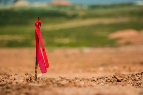 Metal survey peg with red flag on construction site — Stock Photo, Image