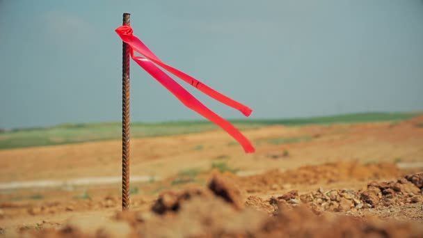 Metalen enquête peg met rode vlag op bouwplaats — Stockvideo