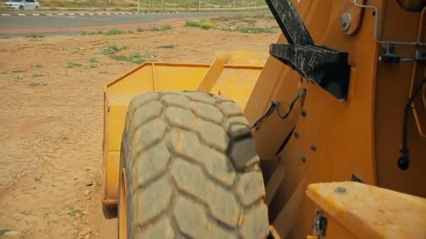 Tractor con una excavadora moviendo el suelo en un sitio de construcción — Vídeo de stock